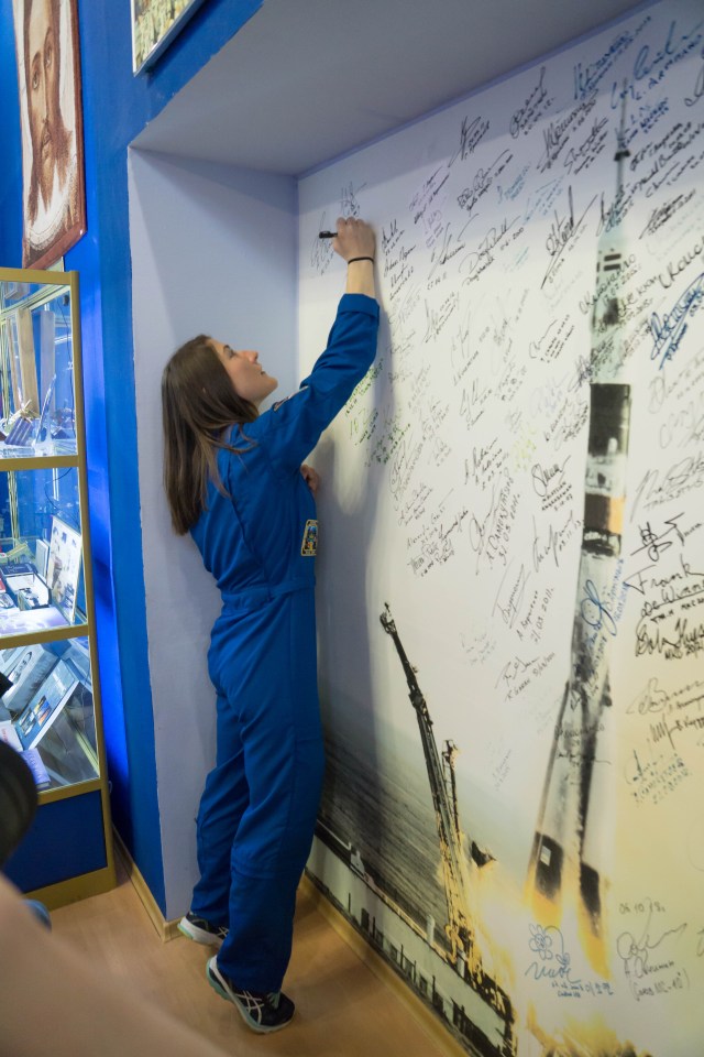 At the Baikonur Cosmodrome Museum in Kazakhstan, Expedition 59 crew member Christina Koch of NASA signs a wall mural bearing the names of those who have flown in space March 10 in traditional pre-launch activities. Koch, Nick Hague of NASA and Alexey Ovchinin of Roscosmos will launch March 14, U.S. time, in the Soyuz MS-12 spacecraft from the Baikonur Cosmodrome for a six-and-a-half month mission on the International Space Station.