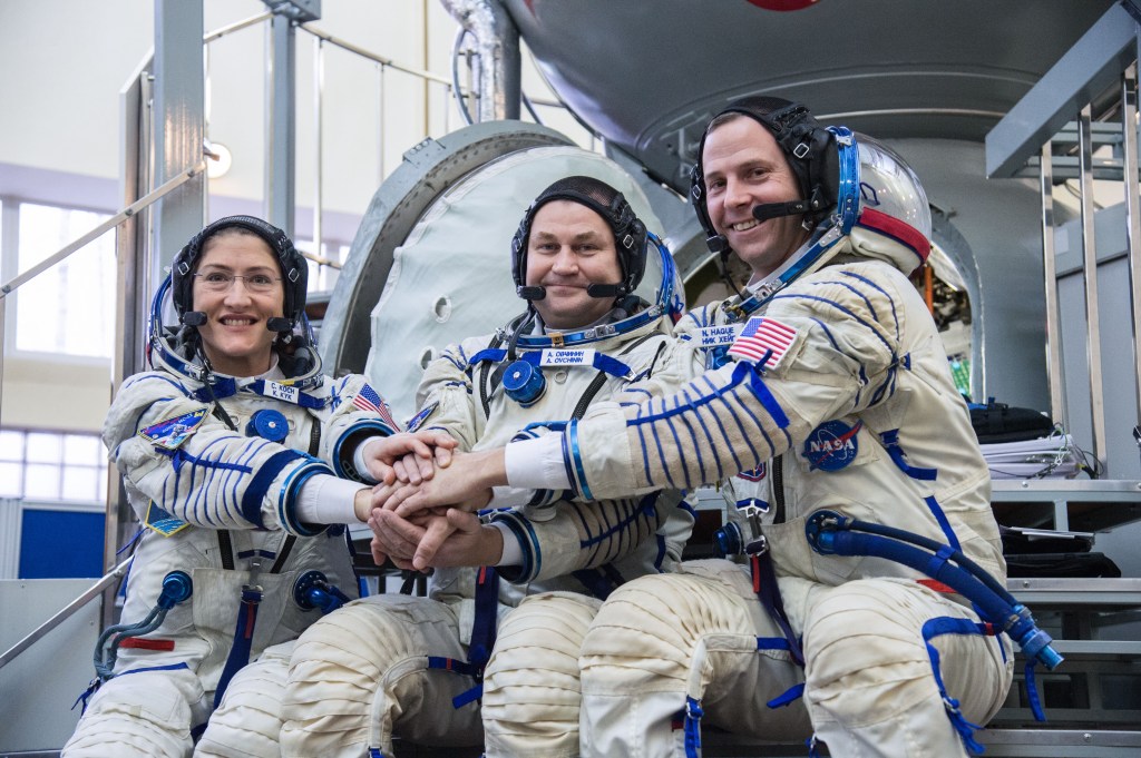 At the Gagarin Cosmonaut Training Center in Star City, Russia, Expedition 59 crew members Christina Koch of NASA (left), Alexey Ovchinin of Roscosmos (center) and Nick Hague of NASA (right) pose for pictures in front of their Soyuz spacecraft simulator Feb. 20 during the second day of final pre-launch qualifications exams. They will launch March 14, U.S. time, in the Soyuz MS-12 spacecraft from the Baikonur Cosmodrome in Kazakhstan for a six-and-a-half month mission on the International Space Station.