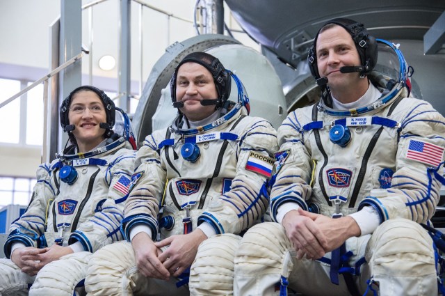 At the Gagarin Cosmonaut Training Center in Star City, Russia, Expedition 59 crewmembers Christina Koch of NASA (left), Alexey Ovchinin of Roscosmos (center) and Nick Hague of NASA (right) listen to reporters’ questions in front of their Soyuz spacecraft simulator Feb. 20 during the second day of final pre-launch qualifications exams. They will launch March 14, U.S. time, in the Soyuz MS-12 spacecraft from the Baikonur Cosmodrome in Kazakhstan for a six-and-a-half month mission on the International Space Station.
