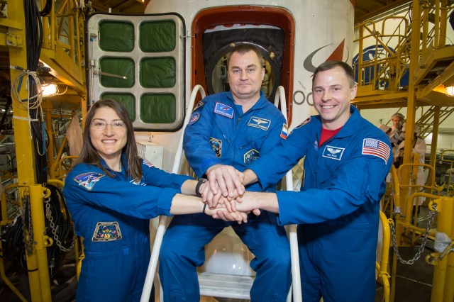 In the Integration Building at the Baikonur Cosmodrome in Kazakhstan, Expedition 59 crew members Christina Koch of NASA (left), Alexey Ovchinin of Roscosmos (center) and Nick Hague of NASA (right) pose for pictures in front of the Soyuz MS-12 spacecraft March 10 during final pre-launch inspections. They will launch March 14, U.S. time, in the Soyuz MS-12 spacecraft from the Baikonur Cosmodrome for a six-and-a-half month mission on the International Space Station.