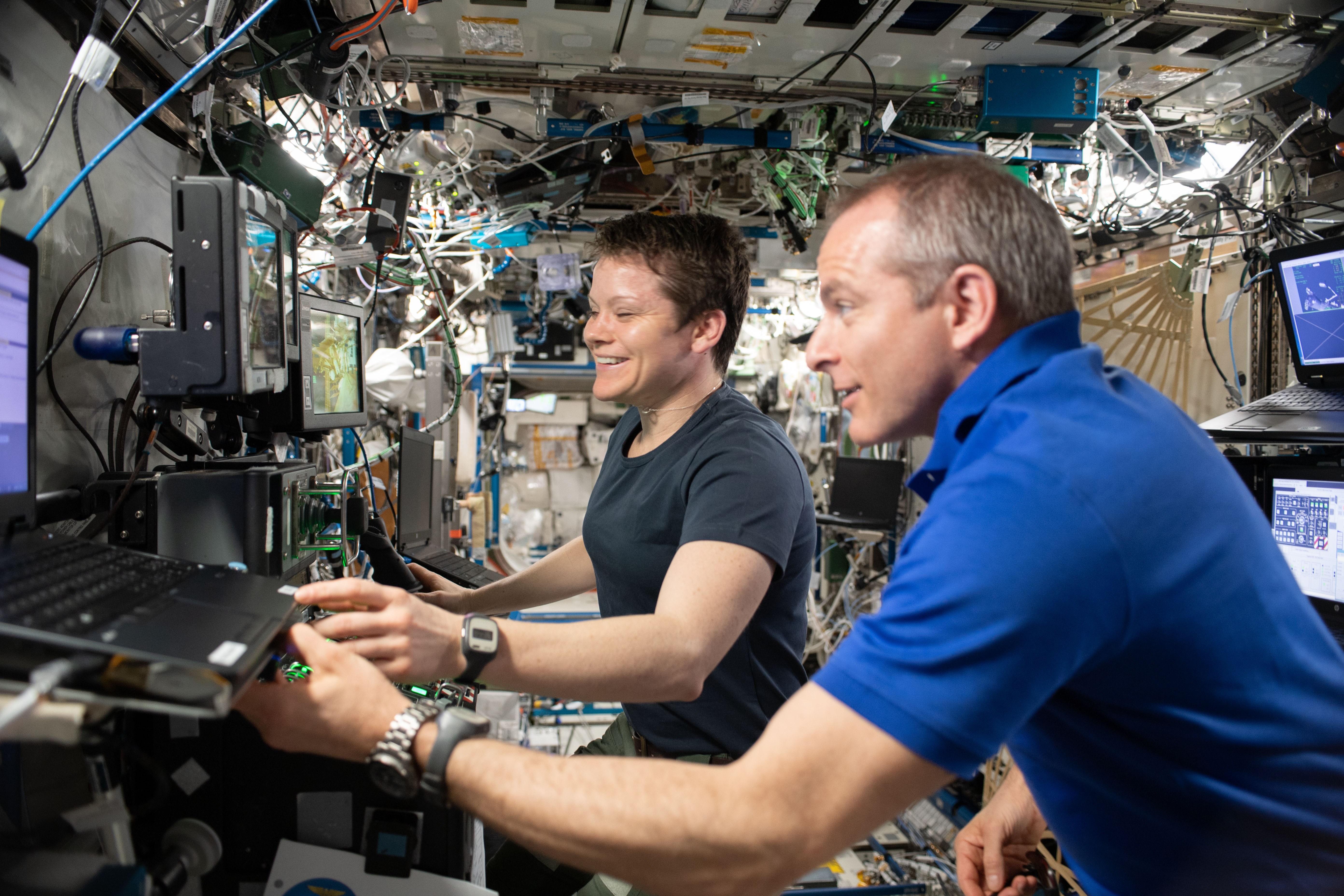 Expedition 59 Flight Engineers David Saint-Jacques and Anne McClain use the robotics workstation inside the U.S. Destiny laboratory module to practice Canadarm2 robotics maneuvers and Cygnus spacecraft capture techniques.