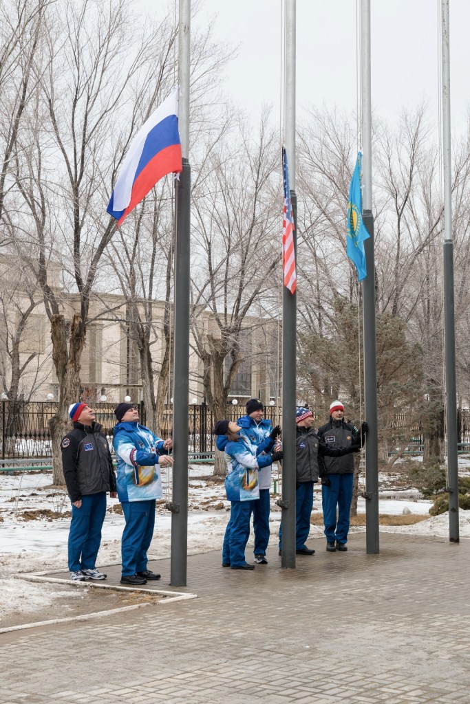 At their Cosmonaut Hotel crew quarters in Baikonur, Kazakhstan, the Expedition 59 prime and backup crew members conduct the traditional raising of the flags of Russia, the U.S. and Kazakhstan Feb. 28 as part of their pre-launch training. From left to right raising the Russian flag are Alexander Skvortsov and Alexey Ovchinin of Roscosmos, raising the U.S. flag are Nick Hague and Christina Koch of NASA and raising the Kazakh flag are Drew Morgan of NASA and Luca Parmitano of the European Space Agency. Hague, Ovchinin and Koch will launch March 14, U.S. time, in the Soyuz MS-12 spacecraft from the Baikonur Cosmodrome in Kazakhstan for a six-and-a-half month mission on the International Space Station.