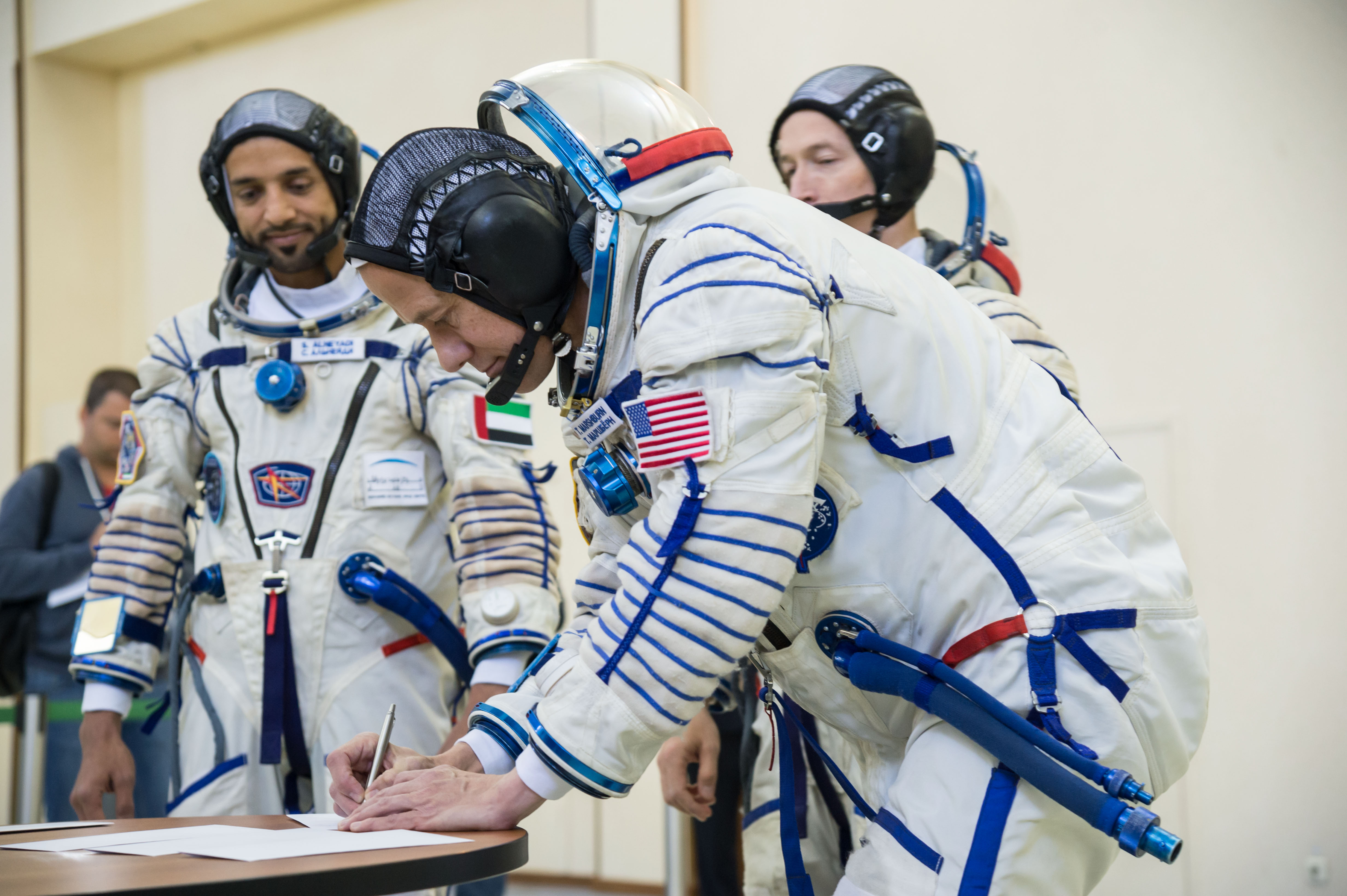 At the Gagarin Cosmonaut Training Center in Star City, Russia, Expedition 61 backup crewmember Tom Marshburn of NASA signs in Aug. 29 for the first day of crew qualification exams. Looking on are the other backups, spaceflight participant Sultan Al-Neyadi of the United Arab Emirates and Sergey Ryzhikov of Roscosmos. They are the backups to the prime crew, spaceflight participant Hazzaa Ali Almansoori of the United Arab Emirates and Expedition 61 crewmembers Oleg Skripochka of Roscosmos and Jessica Meir of NASA, who will launch Sept. 25 from the Baikonur Cosmodrome in Kazakhstan on the Soyuz MS-15 spacecraft for a mission on the International Space Station.