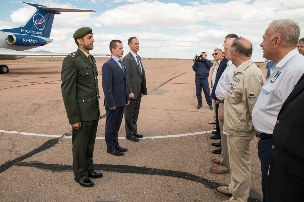 At the airport in Baikonur, Kazakhstan, backup crewmembers Sultan Al-Neyadi of the United Arab Emirates (left) who is a spaceflight participant and Expedition 61 backups Sergey Ryzhikov of Roscosmos (center) and Tom Marshburn of NASA (right) report to Russian space officials Sept. 10 upon their arrival at their launch site. They are the backups to the prime crew, spaceflight participant Hazzaa Ali Almansoori of the United Arab Emirates and Expedition 61 crewmembers Oleg Skripochka of Roscosmos and Jessica Meir of NASA, who will launch on Sept. 25 from the Baikonur Cosmodrome on the Soyuz MS-15 spacecraft for a mission on the International Space Station.