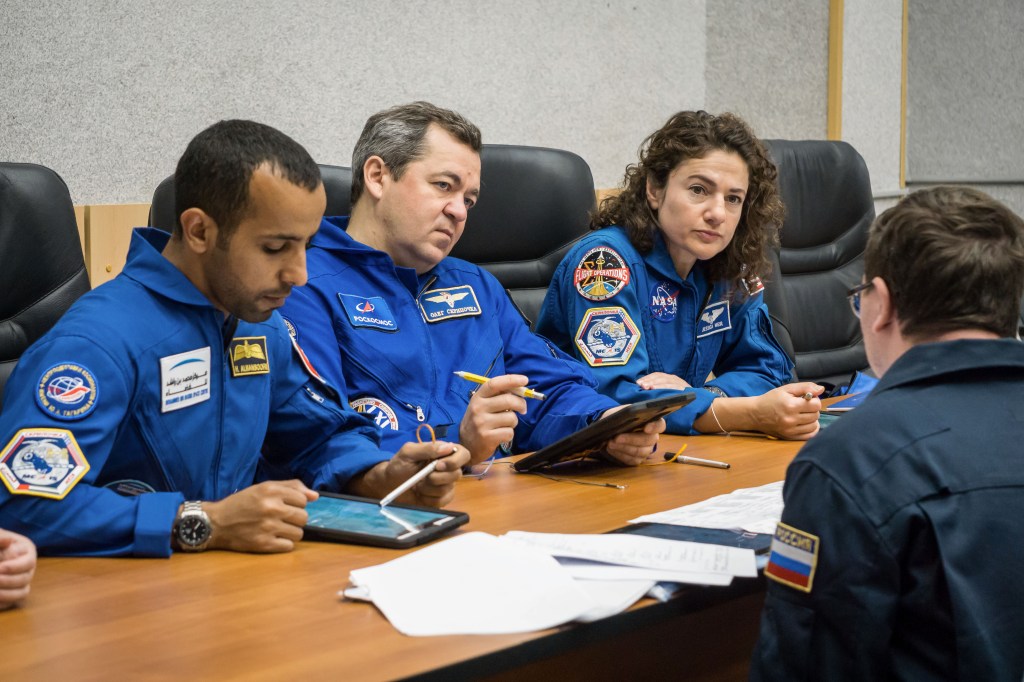 At the Cosmonaut Hotel crew quarters in Baikonur, Kazakhstan, the next crew to launch to the International Space Station reviews its flight plan with training instructors Sept. 18 as part of pre-launch training. Spaceflight participant Hazzaa Ali Almansoori of the United Arab Emirates (left) and Expedition 61 crewmembers Oleg Skripochka of Roscosmos (center) and Jessica Meir of NASA (right) are set to launch Sept. 25 from the Baikonur Cosmodrome in Kazakhstan on the Soyuz MS-15 spacecraft for a mission on the International Space Station.