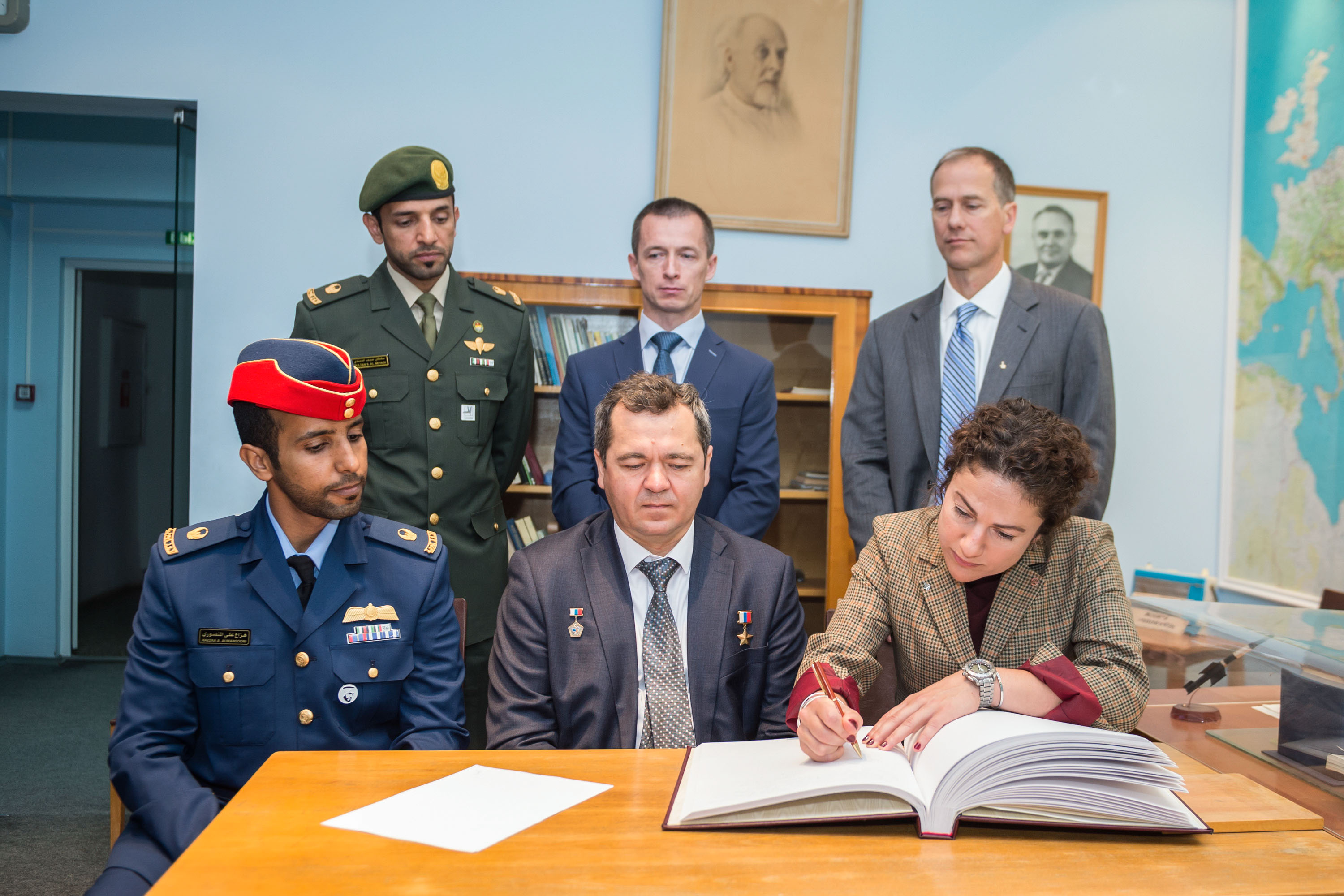 At the Gagarin Cosmonaut Training Center in Star City, Russia, Expedition 61 crewmember Jessica Meir of NASA signs a commemorative book in the Gagarin Museum Sept. 5 as part of pre-launch activities. Looking on in the front row are prime crewmates, spaceflight participant Hazzaa Ali Almansoori of the United Arab Emirates (left) and Expedition 61 Soyuz commander Oleg Skripochka of Roscosmos (center). In the back row are the backups, spaceflight participant Sultan Al-Neyadi of the United Arab Emirates, Sergey Ryzhikov of Roscosmos and Tom Marshburn of NASA. Meir, Skripochka and Almansoori will launch Sept. 25 from the Baikonur Cosmodrome in Kazakhstan on the Soyuz MS-15 spacecraft for a mission on the International Space Station.