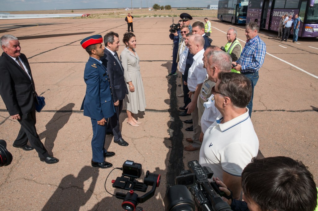 At the airport in Baikonur, Kazakhstan, spaceflight participant Hazzaa Ali Almansoori of the United Arab Emirates (left) and Expedition 61 crewmembers Oleg Skripochka of Roscosmos (center) and Jessica Meir of NASA (right) report to Russian space officials Sept. 10 upon their arrival at the launch site for final pre-launch training. They will launch on Sept. 25 from the Baikonur Cosmodrome on the Soyuz MS-15 spacecraft for a mission on the International Space Station.