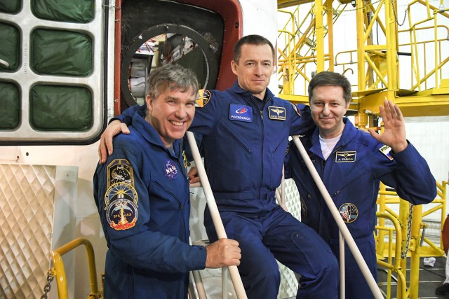 jsc2020e016984 (April 3, 2020) --- At the Baikonur Cosmodrome in Kazakhstan, Expedition 63 backup crewmembers Steve Bowen of NASA (left) and Sergey Ryzhikov (center) and Andrei Babkin (right) of Roscosmos pose for pictures April 3 in front of the Soyuz MS-16 spacecraft as part of pre-launch activities. They are the backups to the prime crew, Chris Cassidy of NASA and Anatoly Ivanishin and Ivan Vagner of Roscosmos, who will launch April 9 on the Soyuz MS-16 spacecraft from Baikonur on April 9 for a six-and-a-half month mission on the International Space Station.