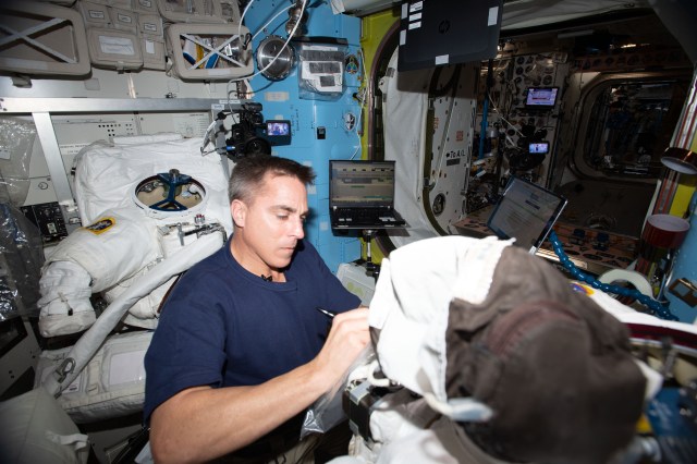 NASA astronaut and Expedition 63 Commander Chris Cassidy cleans cooling loops, replaces components and conducts leak checks inside U.S. spacesuits aboard the International Space Station's Quest airlock.