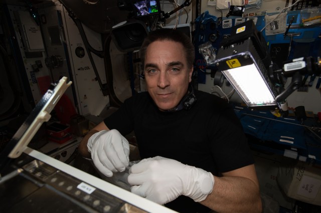 NASA astronaut and Expedition 63 Commander Chris Cassidy configures the new Spectrum imager that will view the cellular growth of plants in multiple wavelengths.