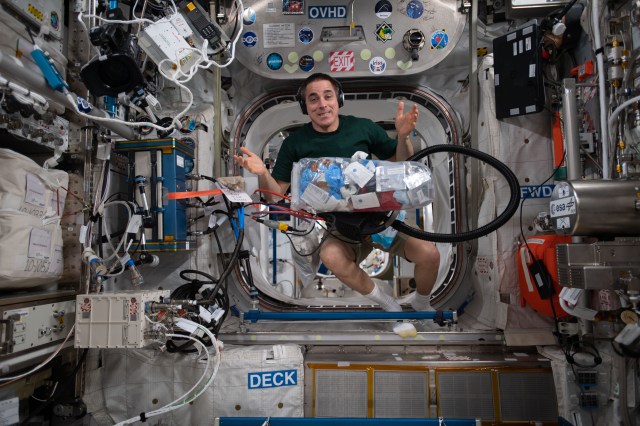 NASA astronaut and Expedition 63 Commander Chris Cassidy collects trash for disposal during weekend housekeeping activities aboard the International Space Station.