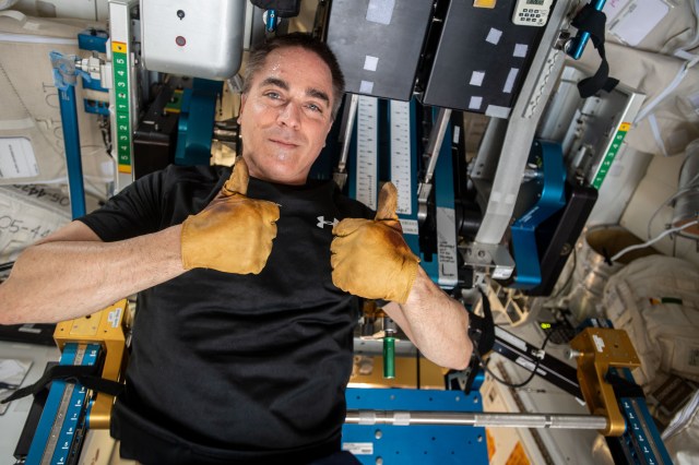 NASA astronaut and Expedition 63 Commander Chris Cassidy gives a thumbs up during set up of exercise equipment aboard the International Space Station.