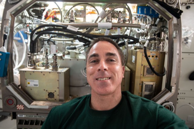 NASA astronaut and Expedition 63 Commander Chris Cassidy poses for a portrait in front of the Microgravity Science Glovebox as he was setting up the Packed Bed Reactor Experiment inside the research device. The new science hardware is exploring technology to support water recovery, planetary surface processing and oxygen production.
