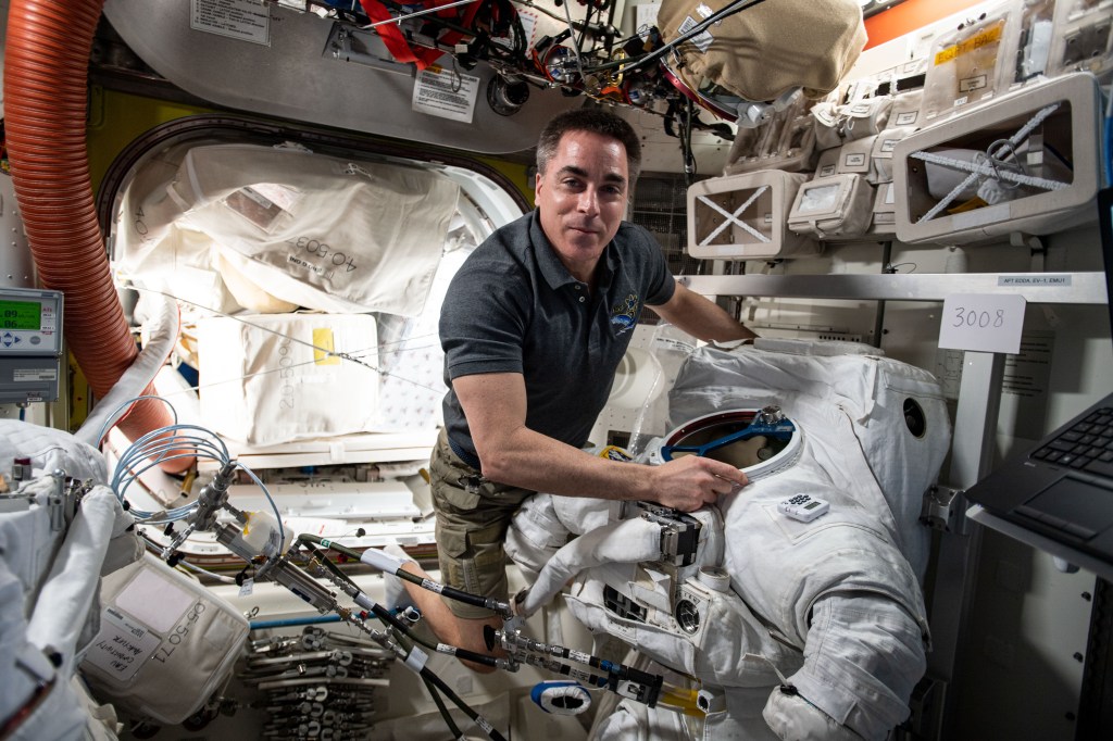 NASA astronaut and Expedition 63 Commander Chris Cassidy works on a U.S. spacesuit inside the Quest airlock of the International Space Station.