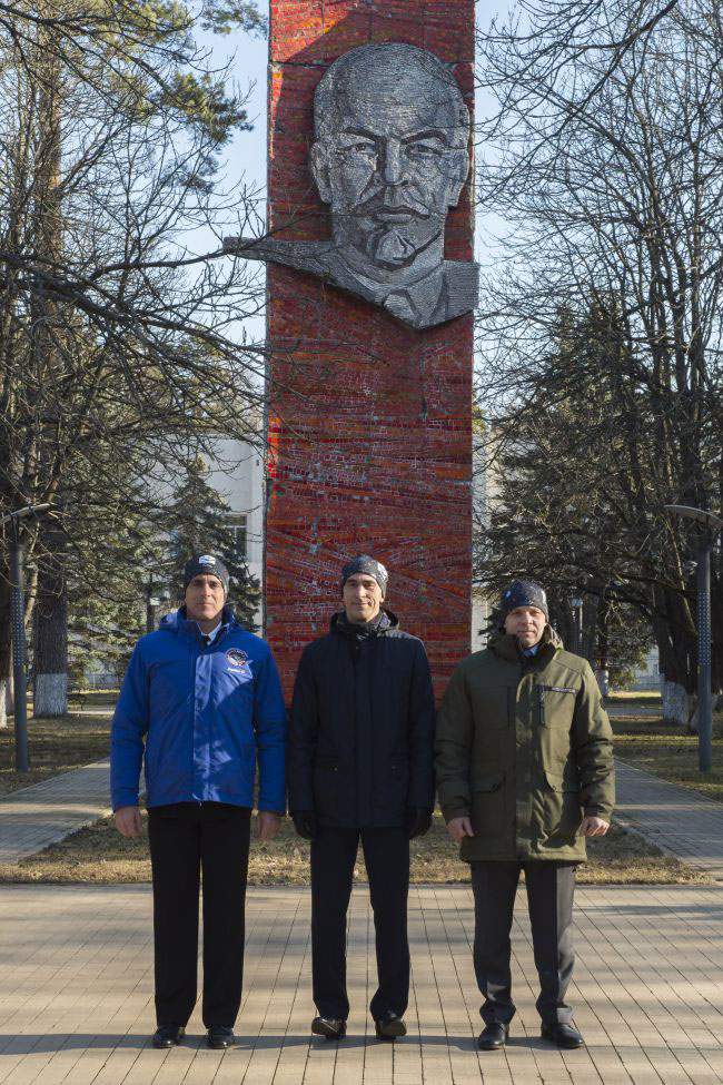 At the Gagarin Cosmonaut Training Center in Star City, Russia, Expedition 63 crewmembers Chris Cassidy of NASA (left) and Anatoly Ivanishin (center) and Ivan Vagner (right) of Roscosmos pose for pictures March 24 in front of the statue of Vladimir Lenin prior to their departure for their launch site at the Baikonur Cosmodrome in Kazakhstan. Cassidy, Ivanishin and Vagner will launch April 9 on the Soyuz MS-16 spacecraft from the Baikonur Cosmodrome in Kazakhstan for a six-and-a-half month mission on the International Space Station.