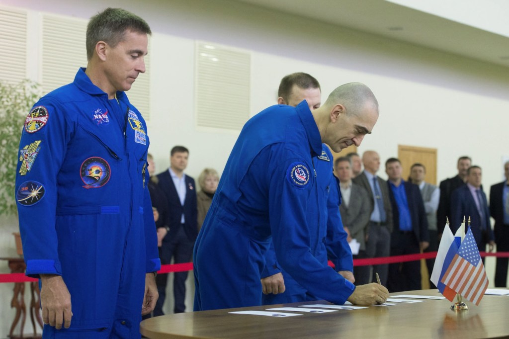 At the Gagarin Cosmonaut Training Center in Star City, Russia, Expedition 63 crewmember Anatoly Ivanishin of Roscosmos (center) signs in for qualification exams March 11 as crewmate Chris Cassidy of NASA (left) looks on. Ivanishin, Cassidy and Ivan Vagner of Roscosmos are preparing for their scheduled launch April 9 in the Soyuz MS-16 spacecraft from the Baikonur Cosmodrome in Kazakhstan for a six-and-a-half month mission on the International Space Station.