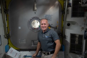 Expedition 63 Flight Engineer Doug Hurley of NASA is pictured in the Quest airlock after assisting NASA spacewalkers (out of frame) Bob Behnken and Chris Cassidy into the crew lock before their spacewalk on June 26.