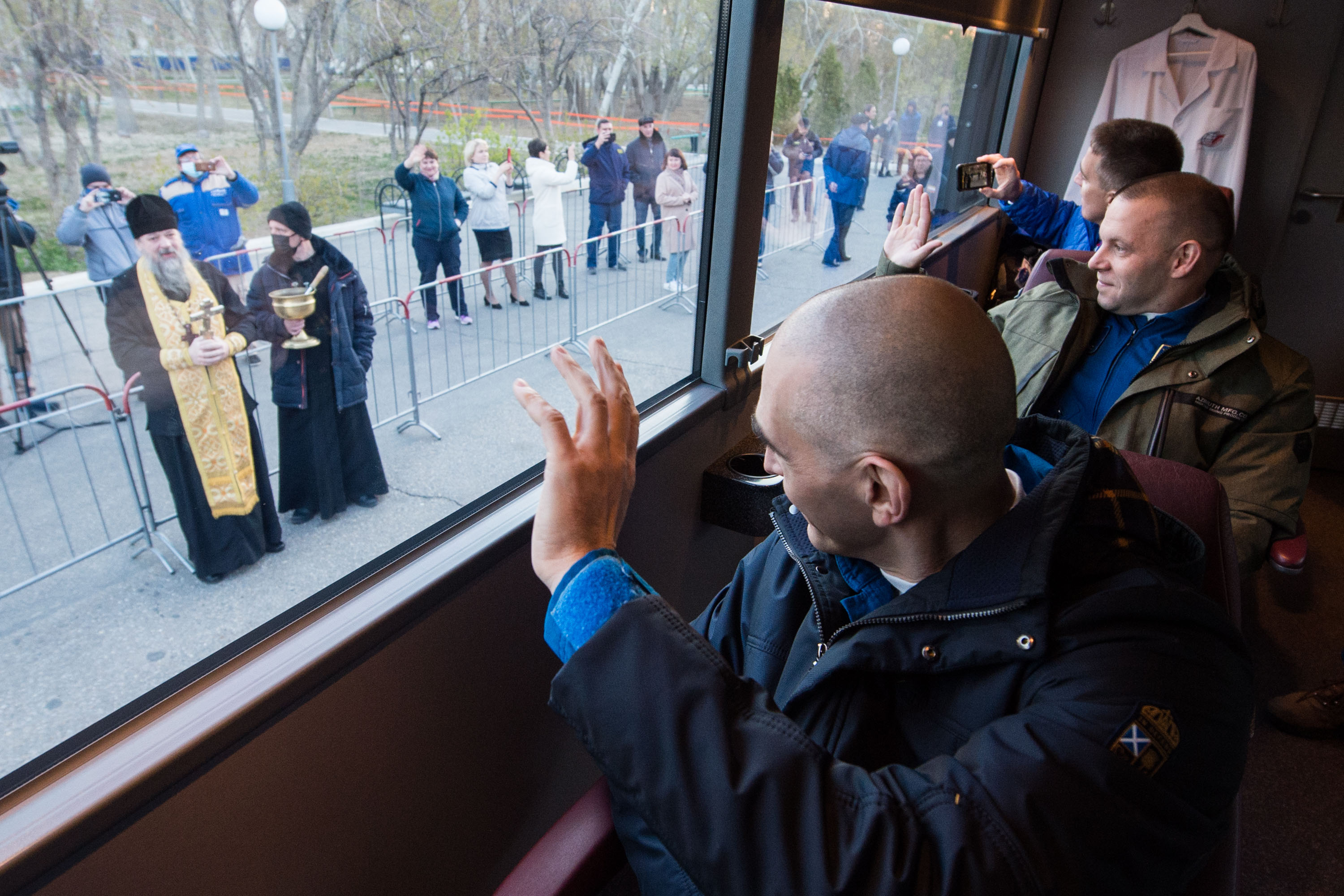 Expedition 63 crewmembers Anatoly Ivanishin, left, Ivan Vagner of Roscosmos, center, and Chris Cassidy of NASA, right, wave farewell as they depart their Cosmonaut Hotel crew quarters in Baikonur, Kazakhstan to travel to their suit up facility for launch on the Soyuz MS-16 rocket from the Baikonur Cosmodrome, Thursday, April 9, 2020. They are beginning a six-and-a-half month mission on the International Space Station.