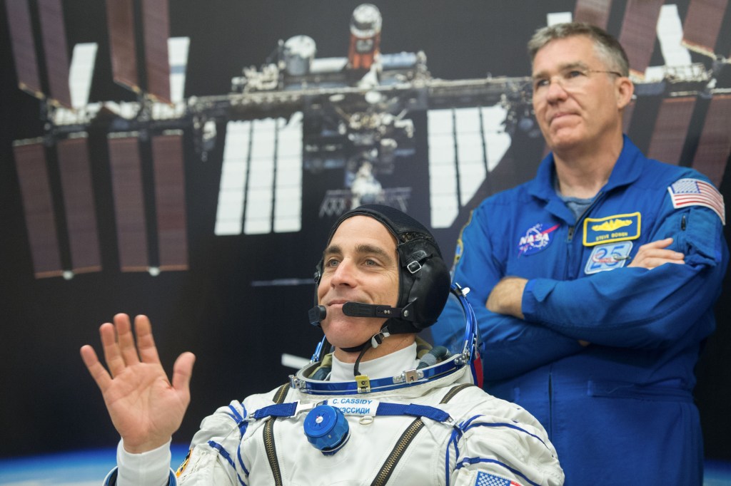Expedition 63 crewmember Chris Cassidy of NASA, foreground, waits to have his Sokol suit pressure checked, as backup crew member Steve Bowen of NASA looks on, Thursday, April 9, 2020 at the Baikonur Cosmodrome in Kazakhstan. A few hours later, Cassidy, Ivan Vagner and Anatoly Ivanishin of Roscosmos lifted off for a six-and-a-half month mission on the International Space Station.