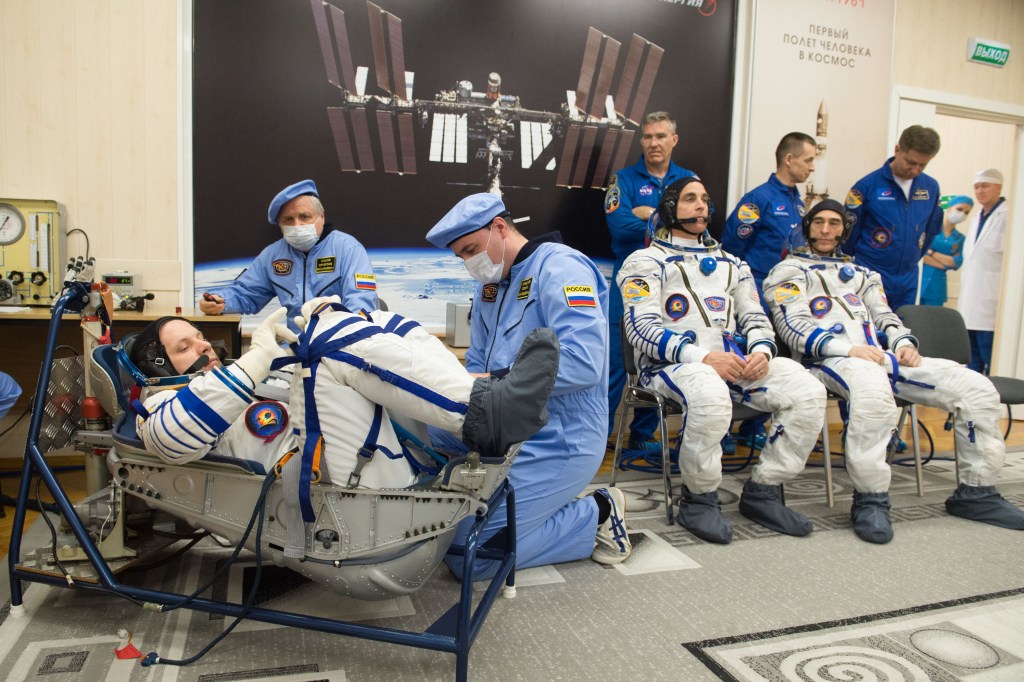Expedition 63 crewmember Ivan Vagner of Roscosmos, left, has his Sokol suit pressure checked ahead of his launch on a Soyuz rocket with Chris Cassidy of NASA, seated center, and Anatoly Ivanishin of Roscosmos, seated right, Thursday, April 9, 2020 at the Baikonur Cosmodrome in Kazakhstan. A few hours later, they lifted off for a six-and-a-half month mission on the International Space Station.
