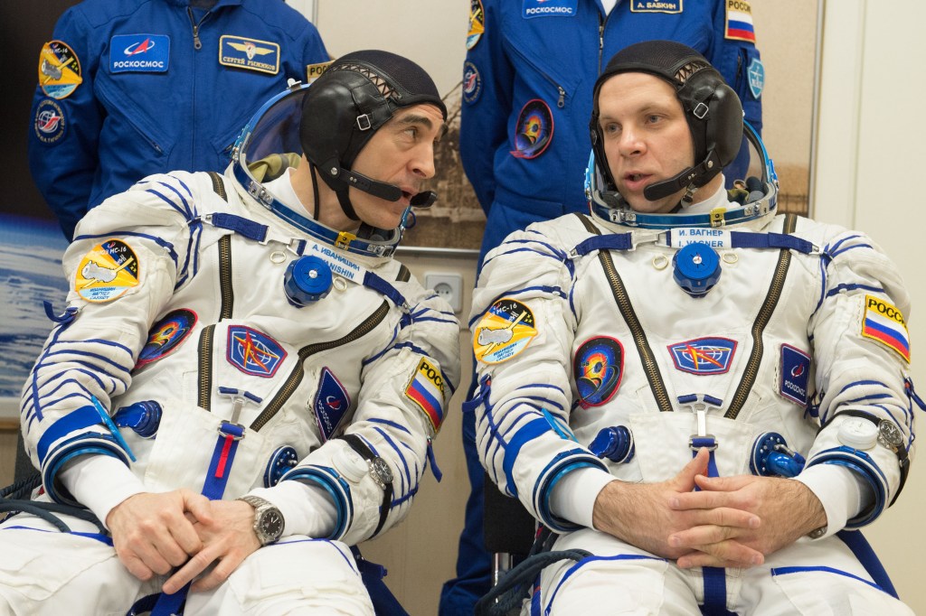Expedition 63 crewmembers Anatoly Ivanishin, left, and Ivan Vagner of Roscosmos, talk as Chris Cassidy of NASA has his Sokol suit pressure checked ahead of their launch on a Soyuz rocket, Thursday, April 9, 2020 at the Baikonur Cosmodrome in Kazakhstan. A few hours later, they lifted off for a six-and-a-half month mission on the International Space Station.