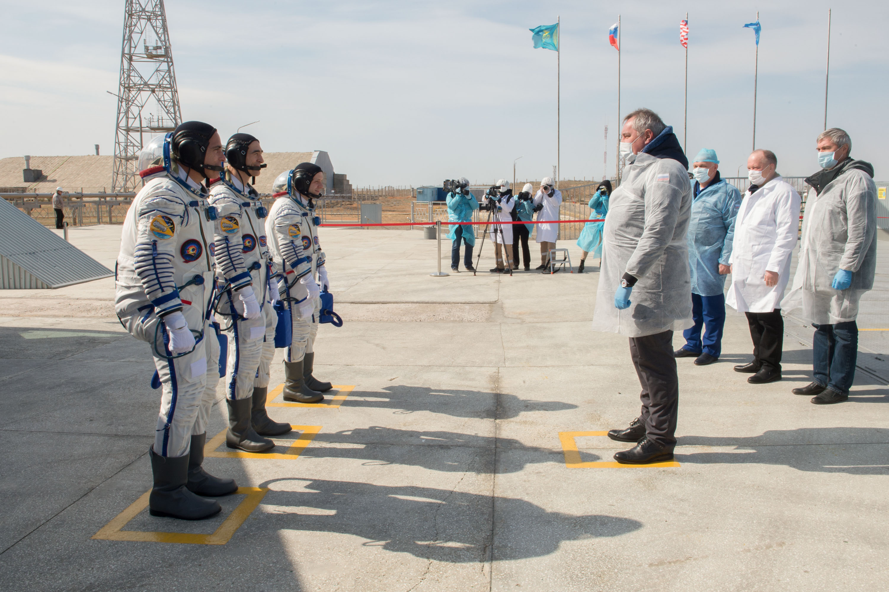 Expedition 63 crewmembers Chris Cassidy of NASA, left, Anatoly Ivanishin and Ivan Vagner of Roscosmos, report to Roscosmos Director General Dmitry Rogozin, right, as they arrive at the launch pad, Thursday, April 9, 2020 at the Baikonur Cosmodrome in Kazakhstan. A few hours later, they lifted off on a Soyuz rocket for a six-and-a-half month mission on the International Space Station.