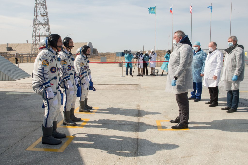 Expedition 63 crewmembers Chris Cassidy of NASA, left, Anatoly Ivanishin and Ivan Vagner of Roscosmos, report to Roscosmos Director General Dmitry Rogozin, right, as they arrive at the launch pad, Thursday, April 9, 2020 at the Baikonur Cosmodrome in Kazakhstan. A few hours later, they lifted off on a Soyuz rocket for a six-and-a-half month mission on the International Space Station.