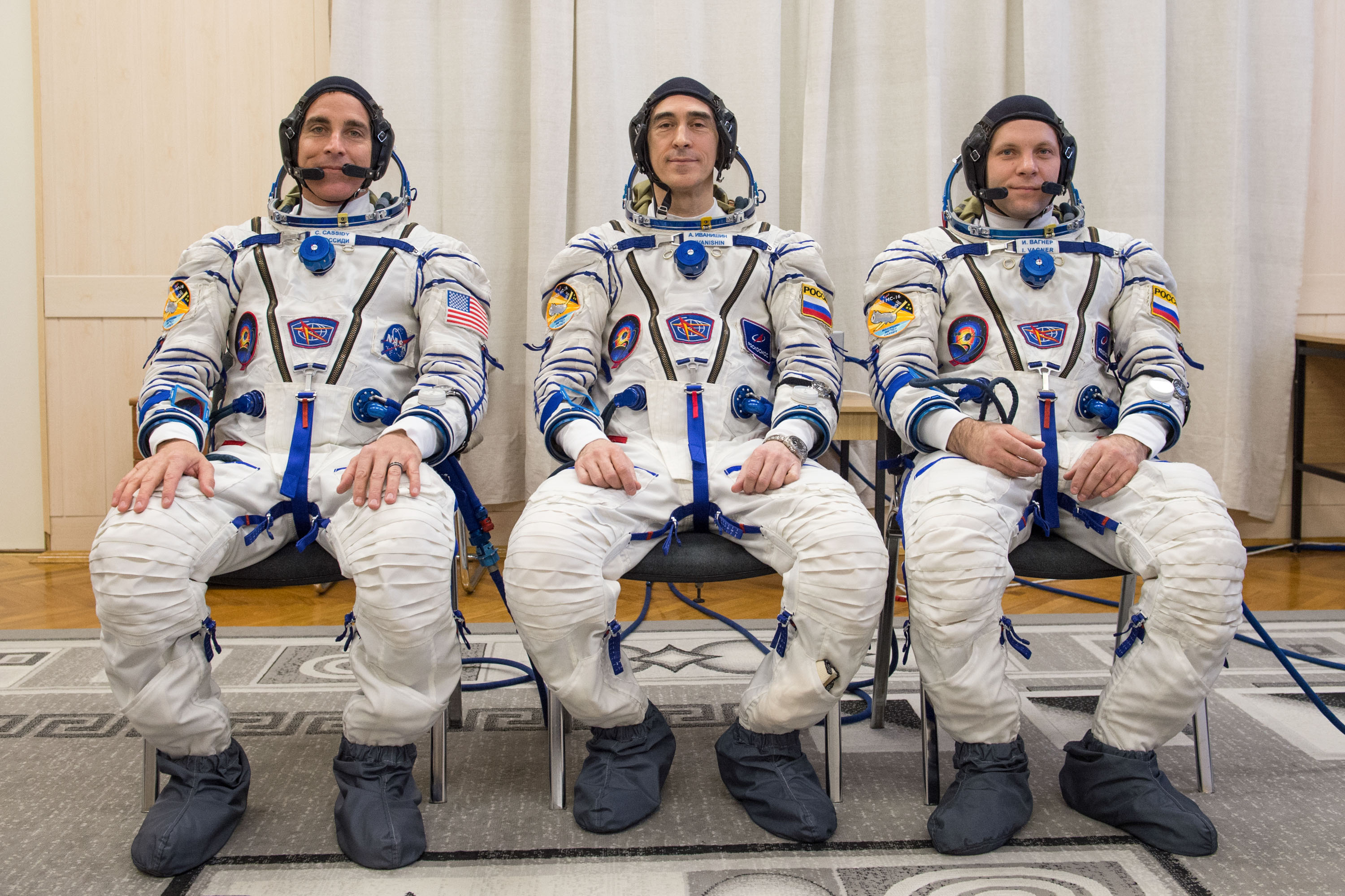 Expedition 63 crewmember Chris Cassidy of NASA, left, Anatoly Ivanishin of Roscosmos, center, and Ivan Vagner of Roscosmos pose for a group photo after suiting up and preparing for leak checks of their launch and entry suits at the Baikonur Cosmodrome in Kazakhstan as they prepared for launch Thursday, April 9, 2020 on the Soyuz MS-16 spacecraft. A few hours later, they lifted off for a six-and-a-half month mission on the International Space Station.