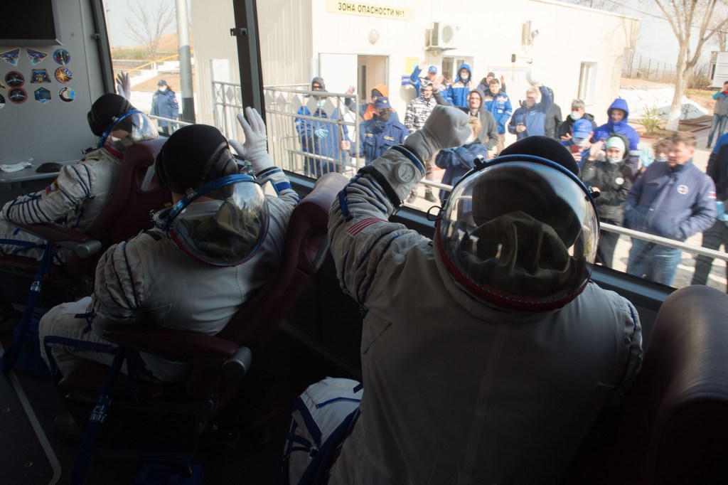 Expedition 63 crewmembers Anatoly Ivanishin, Ivan Vagner of Roscosmos, and Chris Cassidy of NASA wave to workers as they arrive at the launch pad, Thursday, April 9, 2020 at the Baikonur Cosmodrome in Kazakhstan. A few hours later, they lifted off on a Soyuz rocket for a six-and-a-half month mission on the International Space Station.