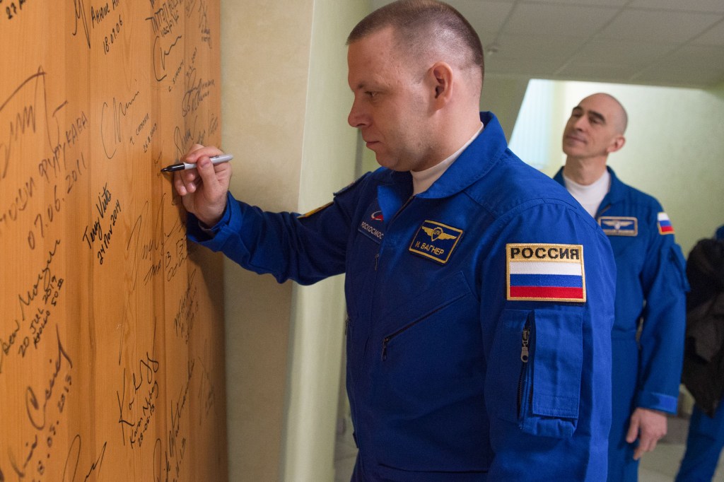 Expedition 63 crewmember Ivan Vagner of Roscosmos signs a door in the Cosmonaut Hotel prior to departing for launch on a Soyuz rocket with Chris Cassidy of NASA, and Anatoly Ivanishin of Roscosmos, Thursday, April 9, 2020 in Baikonur, Kazakhstan. The crew is beginning a six-and-a-half month mission on the International Space Station.