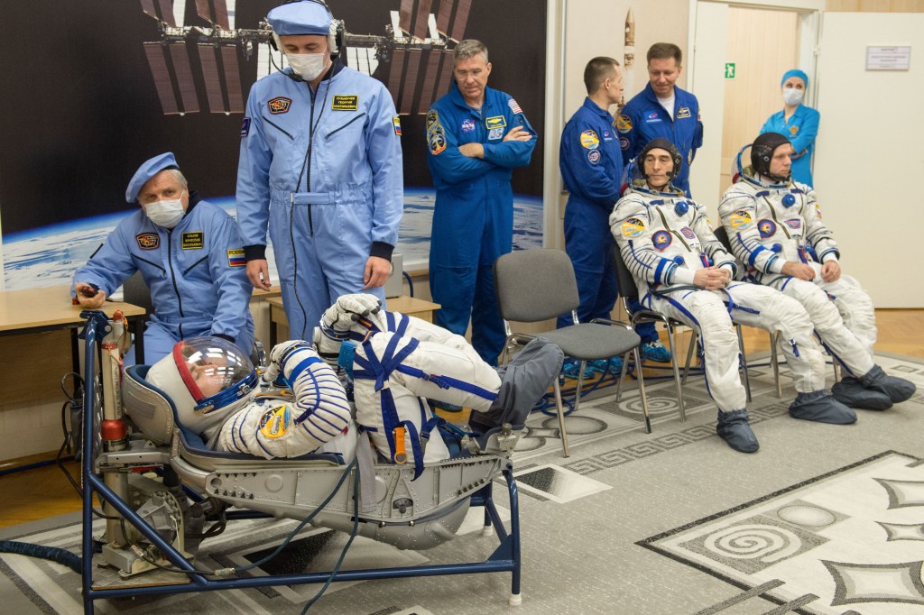 Expedition 63 crewmember Chris Cassidy of NASA, left, has his Sokol suit pressure checked ahead of his launch on a Soyuz rocket with Anatoly Ivanishin of Roscosmos, seated center, and Ivan Vagner of Roscosmos, seated right, Thursday, April 9, 2020 at the Baikonur Cosmodrome in Kazakhstan. A few hours later, they lifted off for a six-and-a-half month mission on the International Space Station.