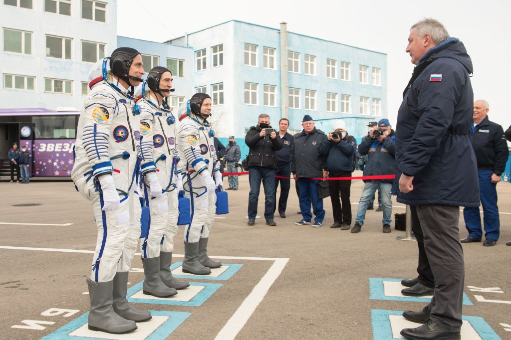 Expedition 63 crewmembers Chris Cassidy of NASA, left, Anatoly Ivanishin and Ivan Vagner of Roscosmos, report to Roscosmos Director General Dmitry Rogozin, right, as they depart building 254 for the launch pad, Thursday, April 9, 2020 at the Baikonur Cosmodrome in Kazakhstan. A few hours later, they lifted off on a Soyuz rocket for a six-and-a-half month mission on the International Space Station.