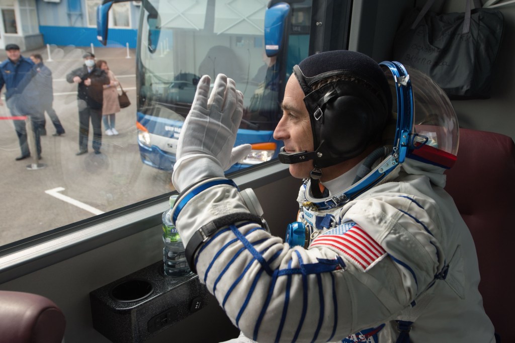 Expedition 63 crewmember Chris Cassidy of NASA waves farewell as he, Anatoly Ivanishin, and Ivan Vagner of Roscosmos depart building 254 via bus for the launch pad, Thursday, April 9, 2020 at the Baikonur Cosmodrome in Kazakhstan. A few hours later, they lifted off on a Soyuz rocket for a six-and-a-half month mission on the International Space Station.