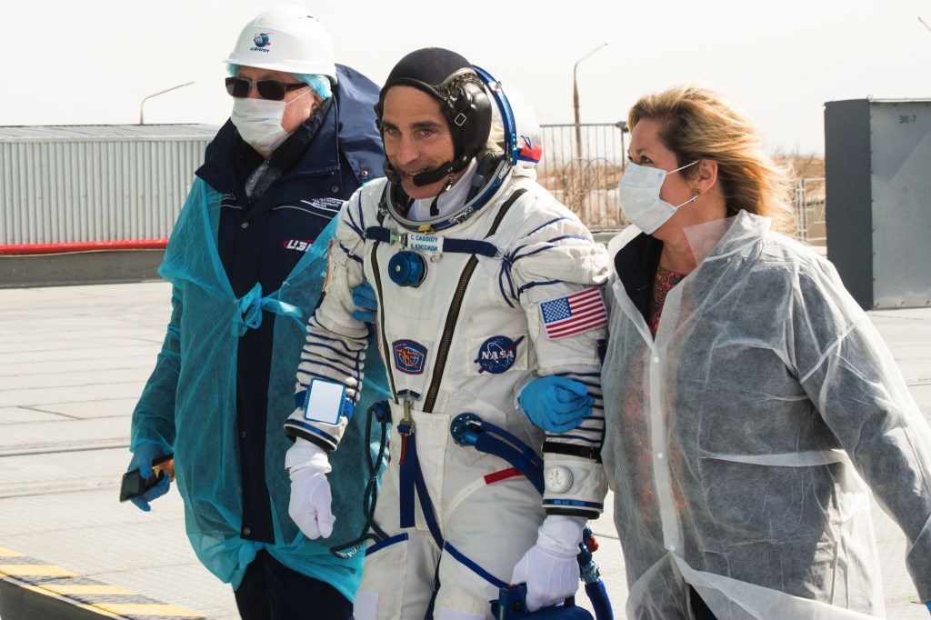 Expedition 63 crewmember Chris Cassidy of NASA walks to board the Soyuz rocket with NASA Director for Human Space Flight Programs, Russia, Tricia Mack on right, ahead of launch with Anatoly Ivanishin and Ivan Vagner of Roscosmos, Thursday, April 9, 2020 at the Baikonur Cosmodrome in Kazakhstan. A few hours later, the trio lifted off on a Soyuz rocket for a six-and-a-half month mission on the International Space Station.