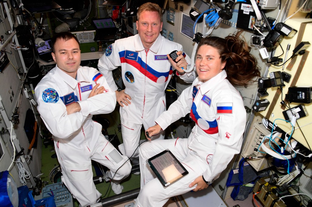 iss068e054581 (Oct. 30, 2022) --- Expedition 68 crew members (from left) Flight Engineer Dmitri Petelin, Commander Sergey Prokopyev, and Flight Engineer Anna Kikina, all cosmonauts representing Roscosmos, pose for a portrait inside the International Space Station's Zvezda service module.
