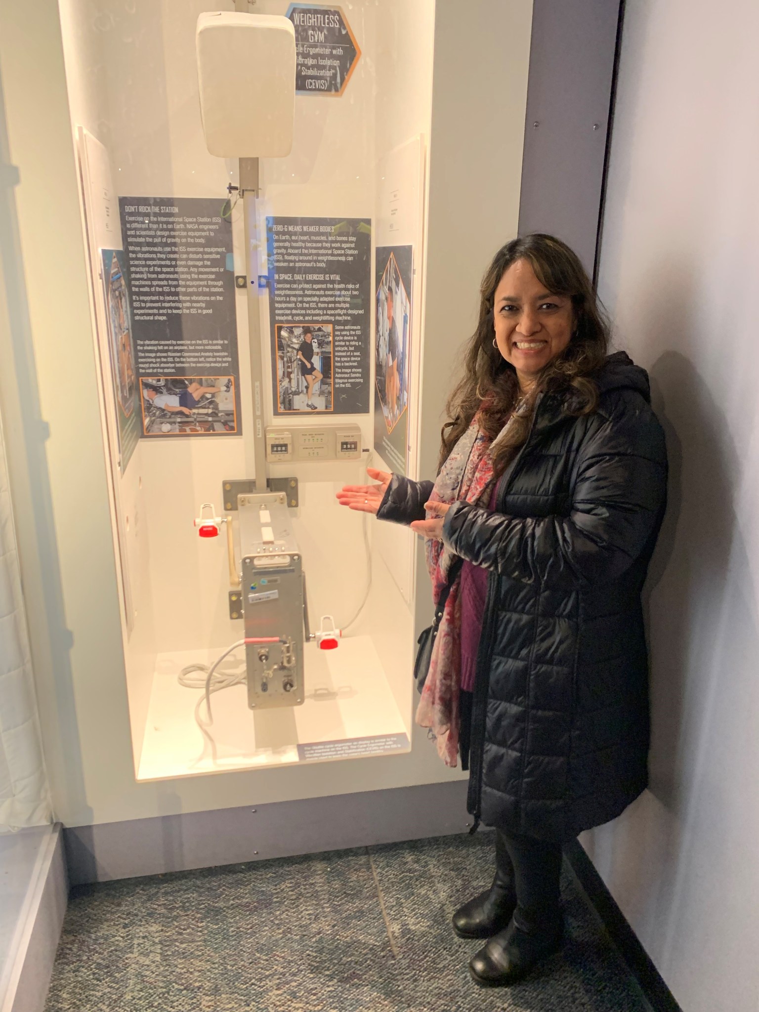 Renita Fincke, , NASA biomedical research projects engineer at Johnson Space Center , stands in front of a space engineering display.