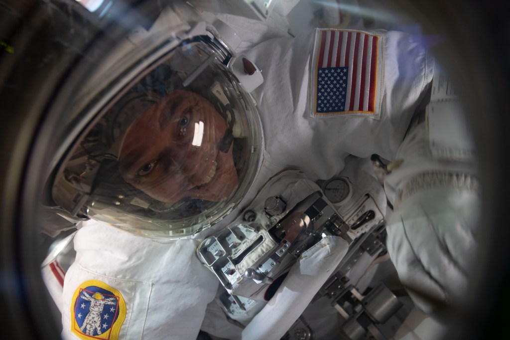 NASA astronaut and Expedition 63 Flight Engineer Bob Behnken is pictured in his U.S. spacesuit inside the crew lock portion of the Quest airlock nearing the end of a spacewalk to replace batteries on the International Space Station's Starboard-6 truss structure.