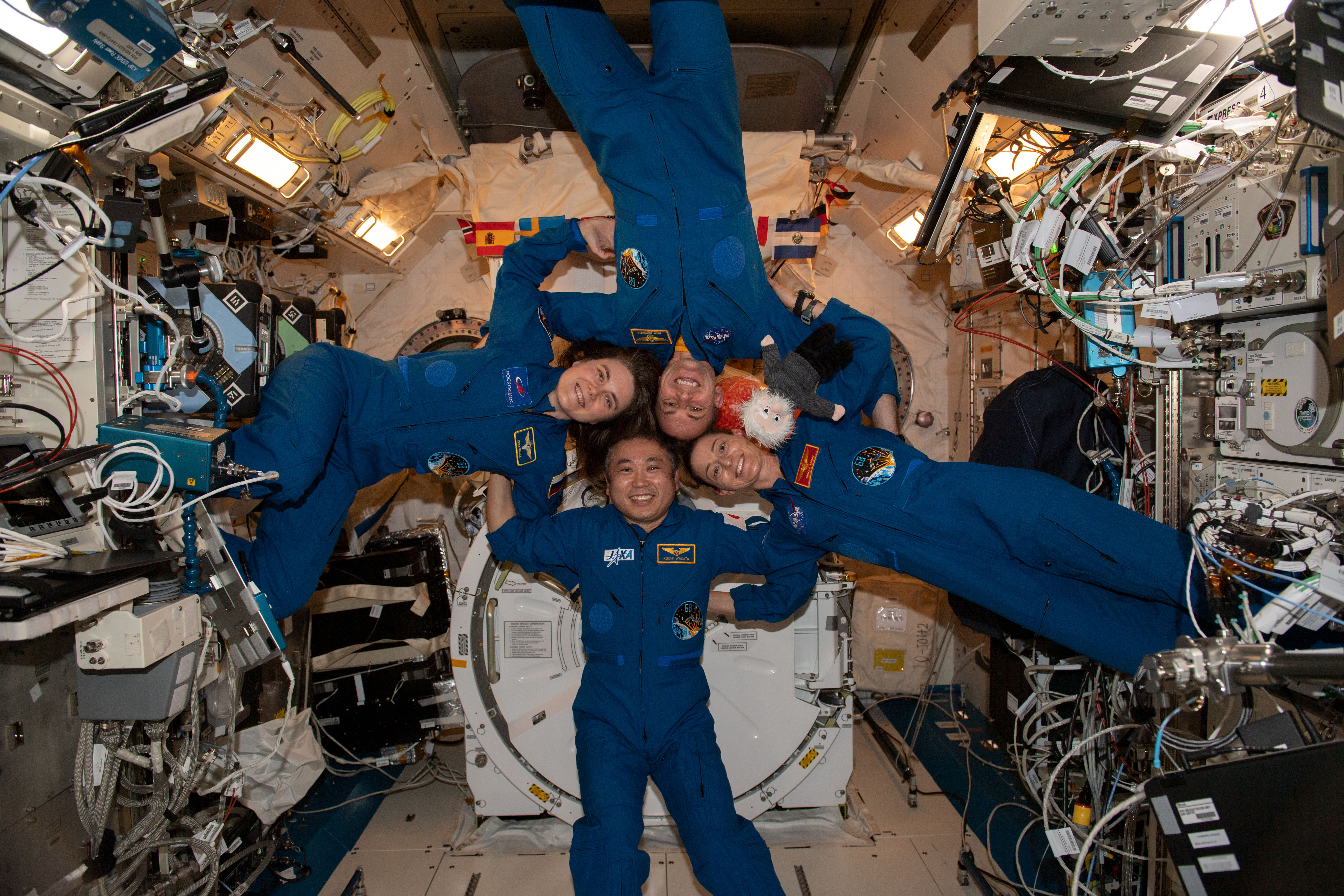 iss068e065044_alt (March 1, 2023) --- Clockwise from left, are Expedition 68 Flight Engineers Anna Kikina of Roscosmos, Josh Cassada and Nicole Mann from NASA, and Koichi Wakata of JAXA (Japan Aerospace Exploration Agency) posing for a fun portrait inside the International Space Station's Kibo laboratory module.