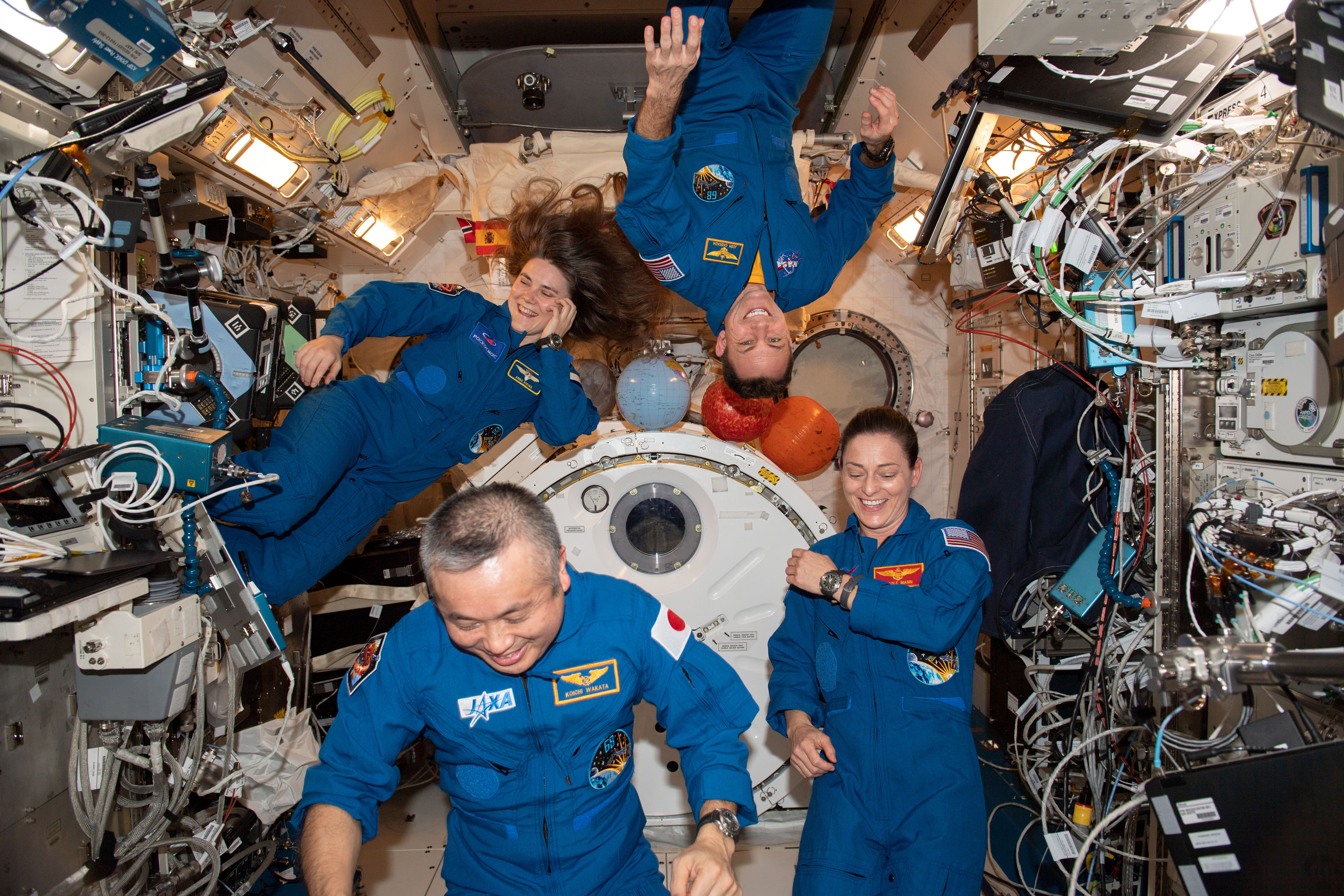 iss068e065048_alt (March 1, 2023) --- Clockwise from top, are Expedition 68 Flight Engineers Josh Cassada and Nicole Mann from NASA, Koichi Wakata of JAXA (Japan Aerospace Exploration Agency), and Anna Kikina of Roscosmos posing for a fun portrait inside the International Space Station's Kibo laboratory module.