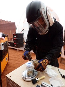 Medical Officer, Nathan Jones, conducts an experiment with "Mars" regolith inside CHAPEA's 1,200 square foot habitat. Credit: NASA