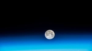 The near Full Moon is pictured just above Earth's atmosphere in this photograph from the International Space Station as it orbited 262 miles above the north Pacific Ocean south of Alaska's Aleutian Islands.