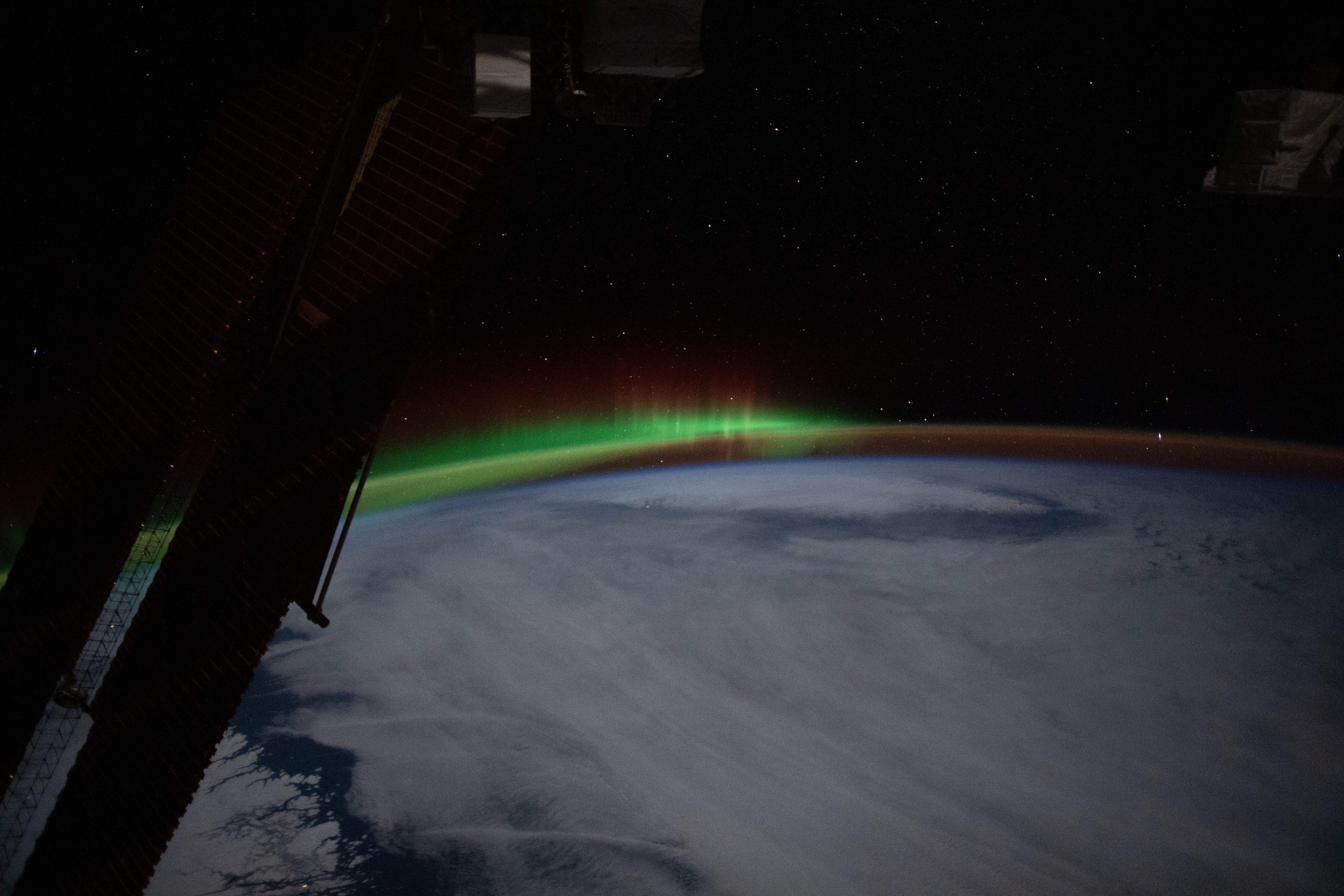 An aurora and an atmospheric glow crown Earth's horizon beneath a starry sky in tis photograph from the International Space Station as it orbited 262 miles above the Canadian province of Quebec.