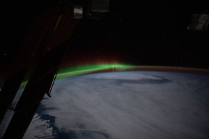 An aurora and an atmospheric glow crown Earth's horizon beneath a starry sky in tis photograph from the International Space Station as it orbited 262 miles above the Canadian province of Quebec.