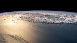 The sun's glint beams off the Atlantic Ocean revealing the island country of the Republic of Cabo Verde (left) off the coast of Africa in this photograph from the International Space Station as it orbited 261 miles above.