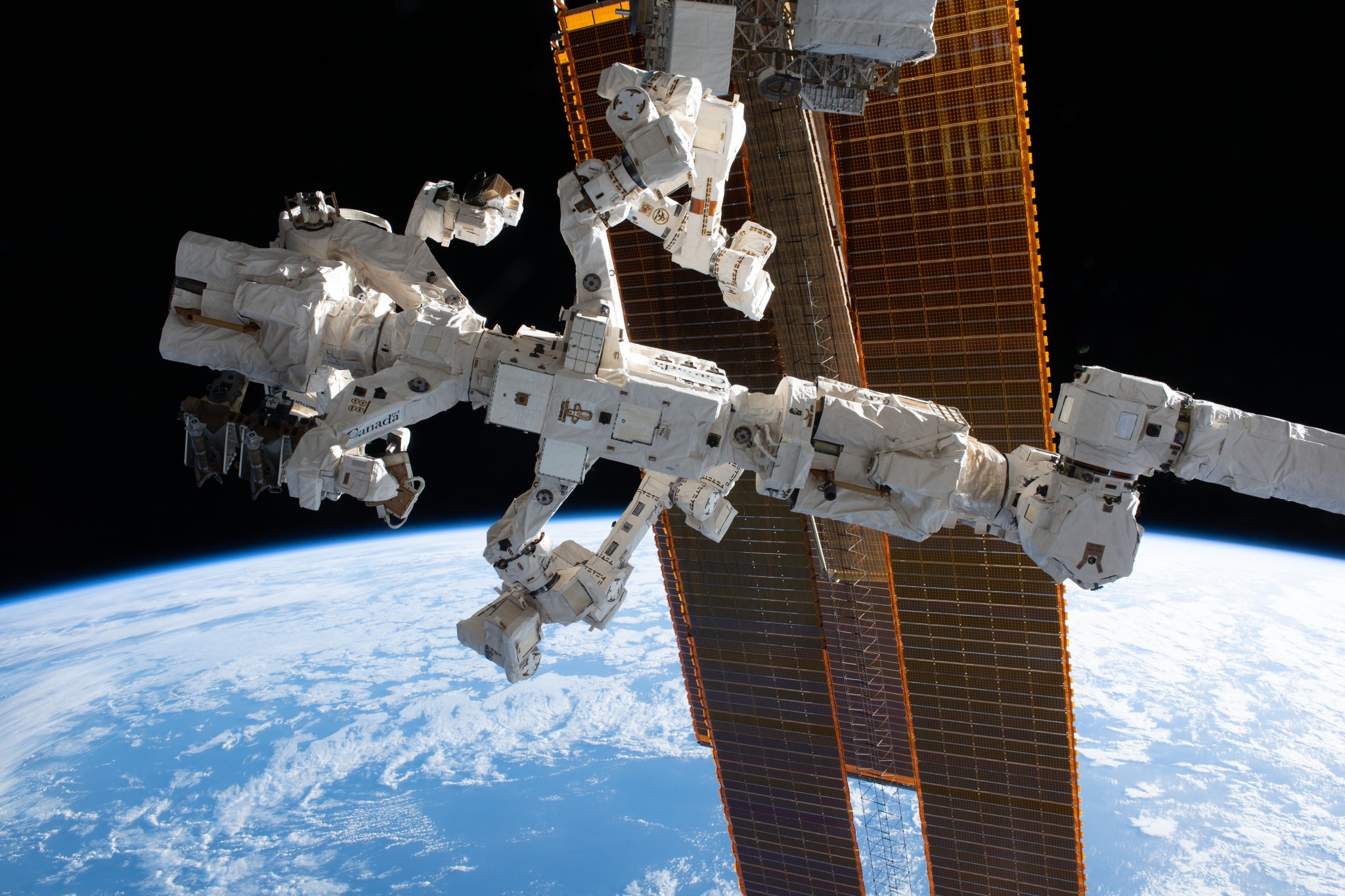 The Special Purpose Dexterous Manipulator (also known as Dextre), a fine-tuned robotic hand designed and built by the Canadian Space Agency, is pictured in front of the International Space Station's main solar arrays as the orbital complex soared 260 miles above the Pacific Ocean. Dextre is attached to the leading end effector, or tip, of the Canadarm2 robotic arm.