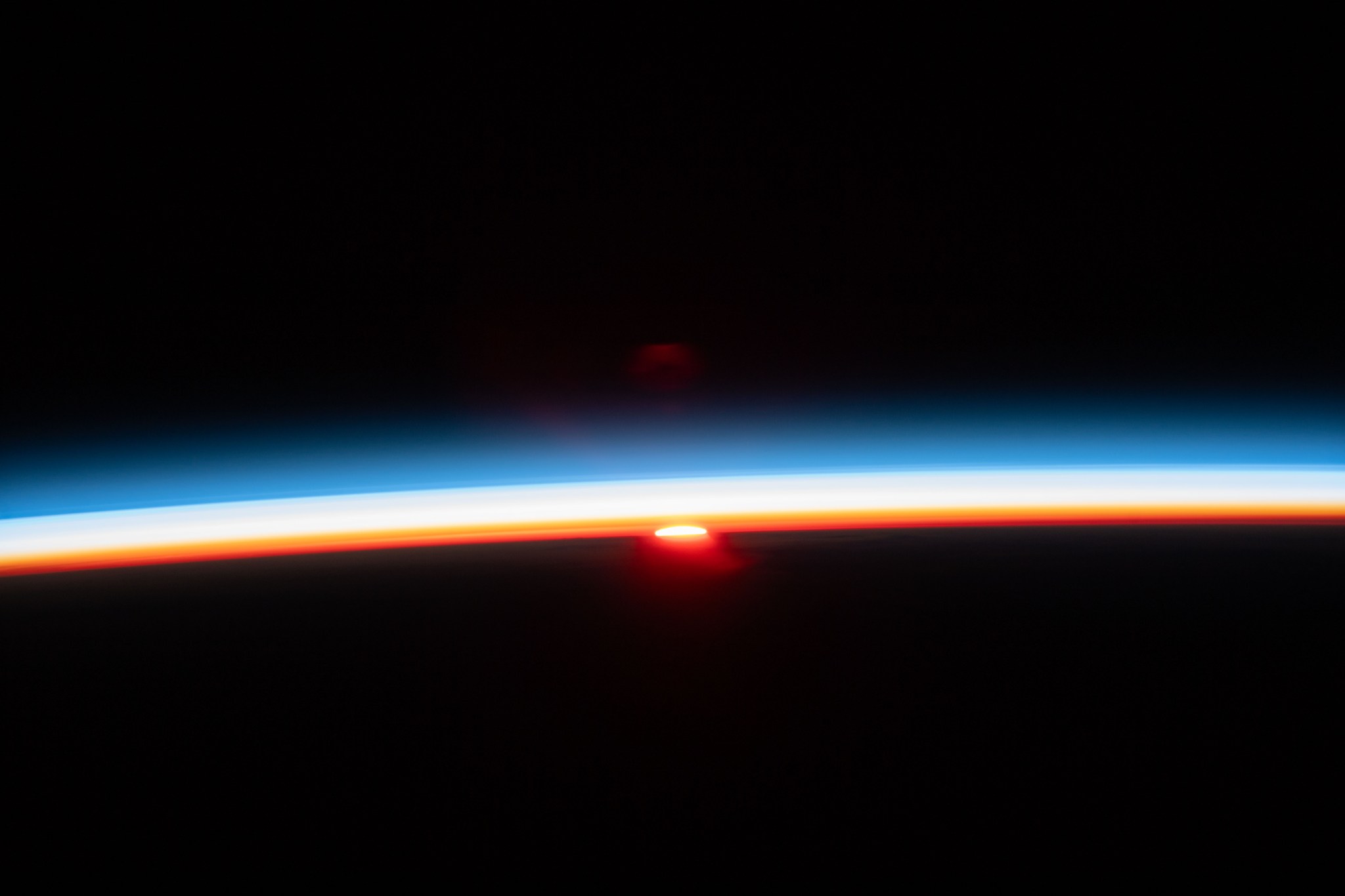 The sun's last rays illuminate Earth's atmosphere in this photograph of an orbital sunset from the International Space Station as it soared 261 miles above the Pacific Ocean off the northern coast of Japan.