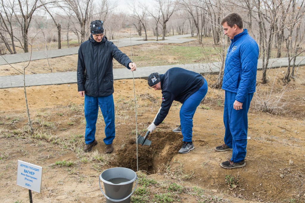 At the Cosmonaut Hotel crew quarters in Baikonur, Kazakhstan, Expedition 63 crewmember Ivan Vagner of Roscosmos (center) plants a tree bearing his name April 1 in traditional pre-launch activities. Looking on are crewmates Anatoly Ivanishin of Roscosmos (left) and Chris Cassidy of NASA (right). They will launch April 9 on the Soyuz MS-16 spacecraft from the Baikonur Cosmodrome in Kazakhstan for a six-and-a-half month mission on the International Space Station. Credit: Andrey Shelepin/Gagarin Cosmonaut Training Center.