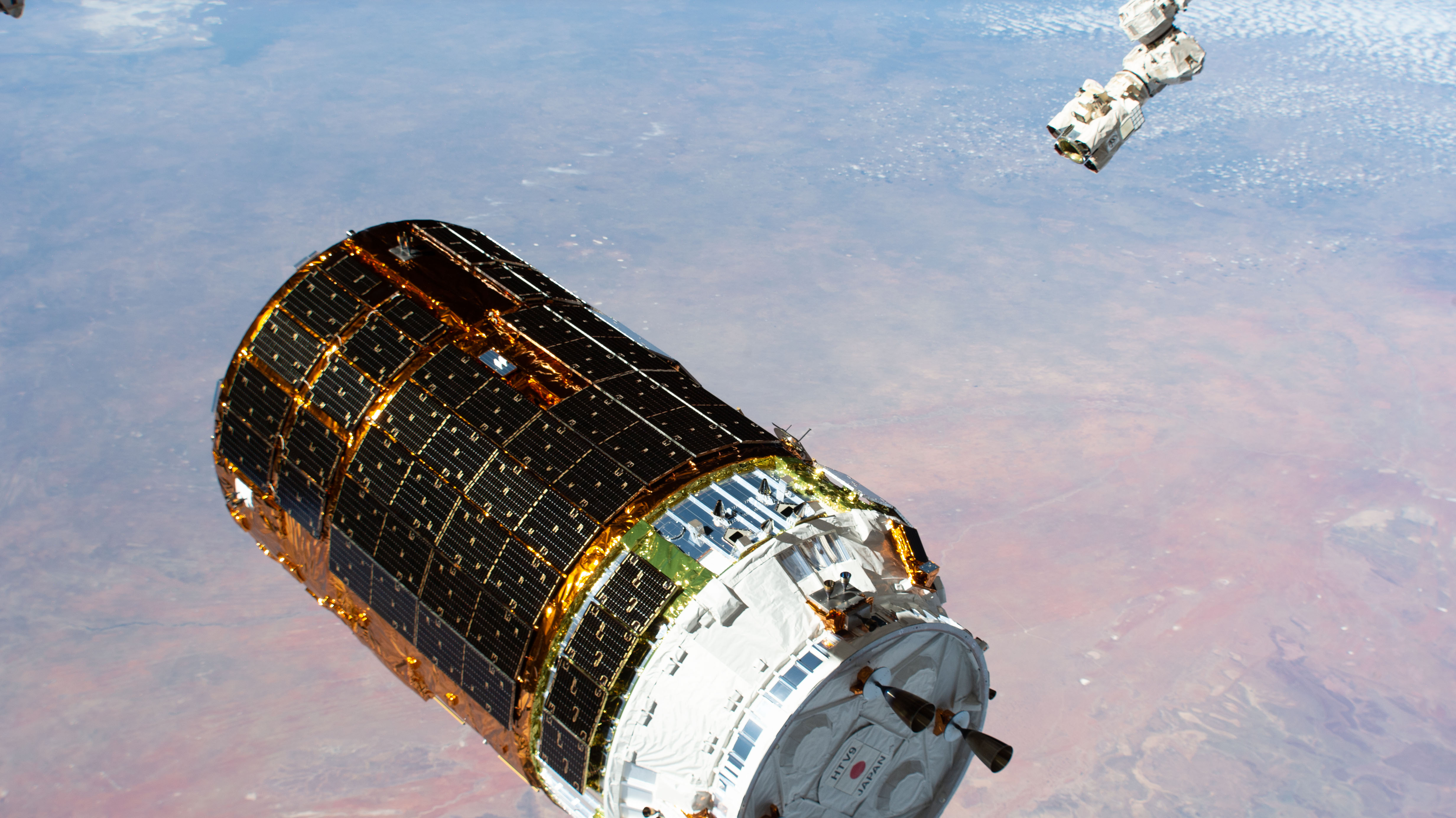 The H-II Transfer Vehicle-9 (HTV-9) from JAXA (Japan Aerospace Exploration Agency) is pictured moments before the Canadarm2 robotic arm (upper right) captured the resupply ship. Expedition 63 Commander Chris Cassidy was at the robotics controls ready to command the Canadarm2 to reach out and grapple the HTV-9 that was carrying over four tons of food, supplies and experiments to replenish the International Space Station crew.