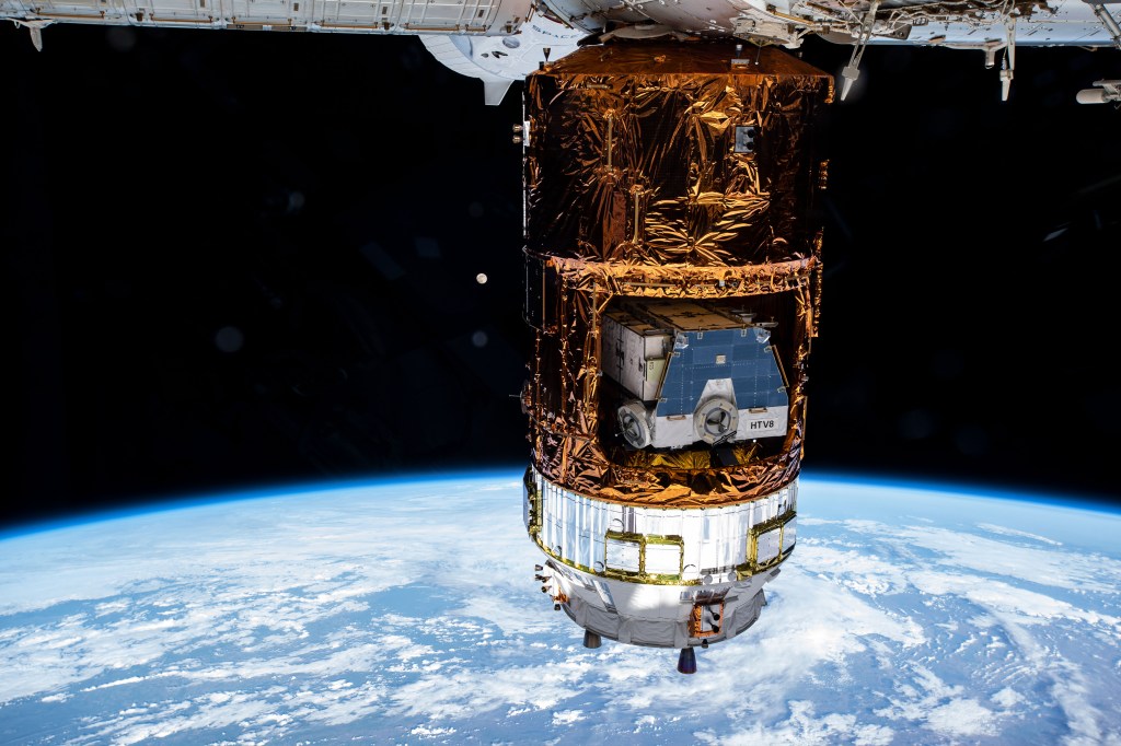 Japan's resupply ship, the H-II Transfer Vehicle-9 (HTV-9), is pictured attached to the International Space Station's Harmony module dwarfing the Moon behind it. Stowed inside the Japanese space freighter is the HTV-8 cargo pallet that was brought up to the station on a previous resupply mission. The pallet contains old nickel-hydrogen batteries for disposal that were disconnected from the station during a series of spacewalks at the end of 2019. Nearly hidden at the top center is the SpaceX Crew Dragon vehicle.