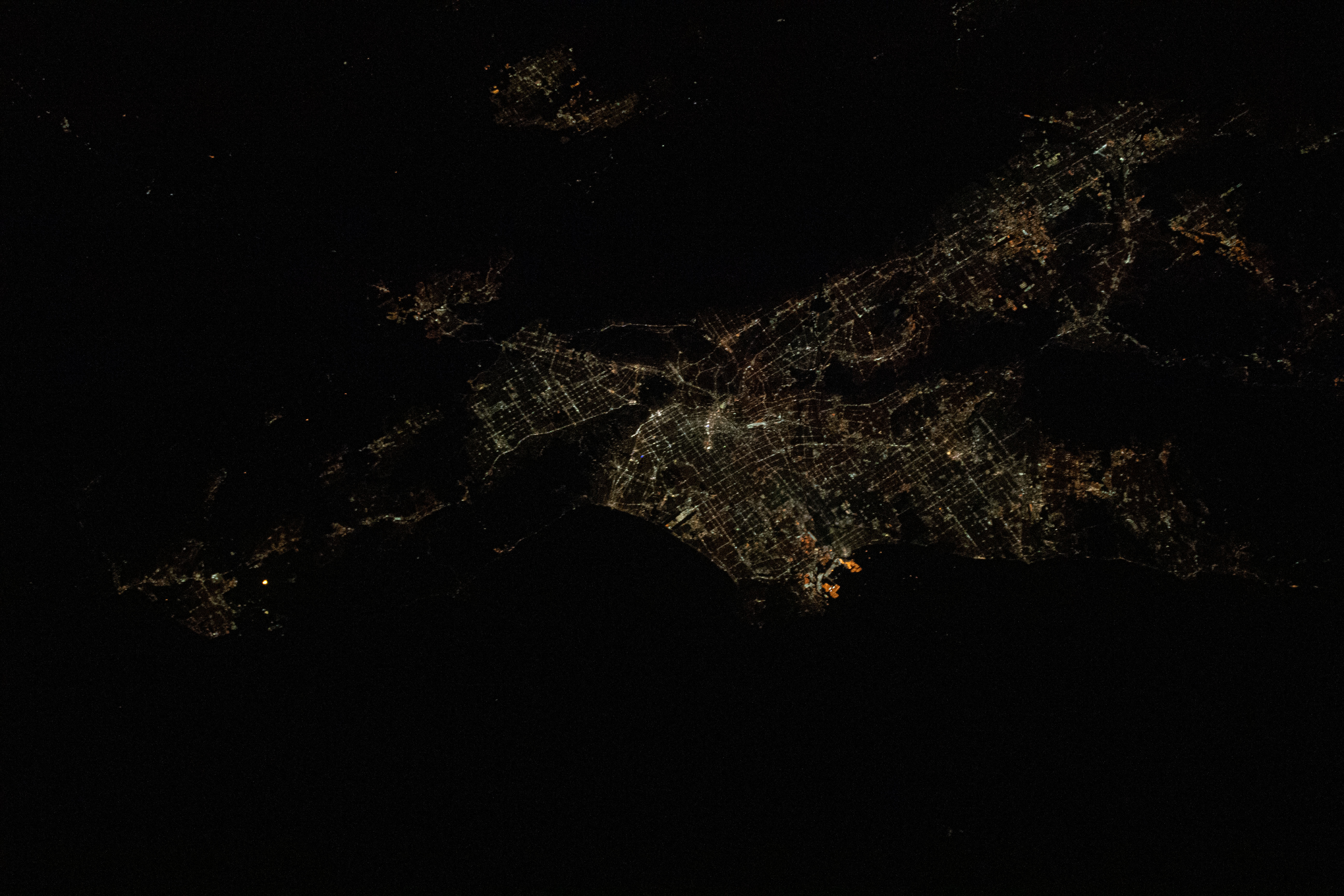 Los Angeles, California is pictured at night as the International Space Station was orbiting 257 miles above the Pacific Ocean and about 215 miles southwest of the L.A. coastline. The bright orange lights at the center are Terminal Island and the Port of Los Angeles.